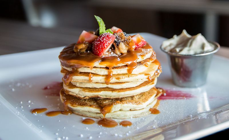 Sweet crepes with strawberries, syrup and mint